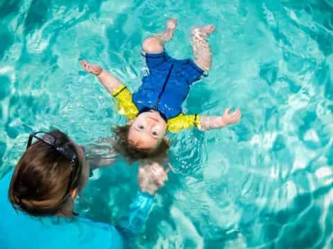 a person and a baby in a pool