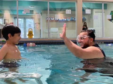 a person and a boy in a pool