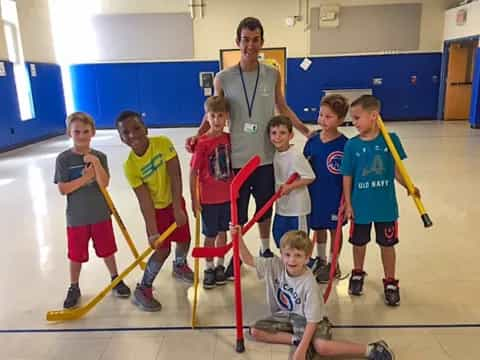 a group of kids holding hockey sticks