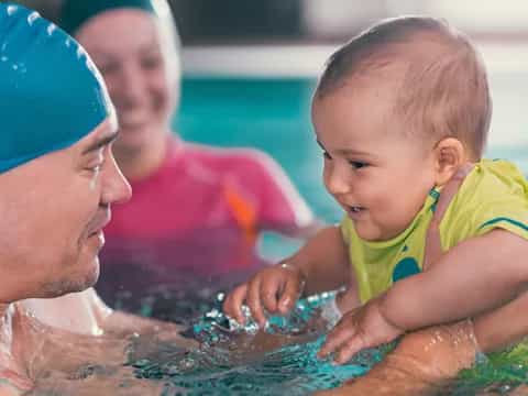a man and a baby playing in water