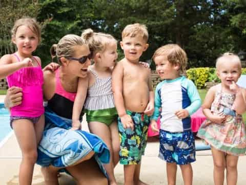 a group of children posing for a photo by a pool