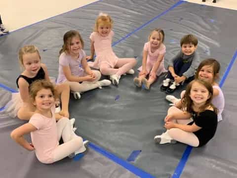 a group of children sitting on a mat