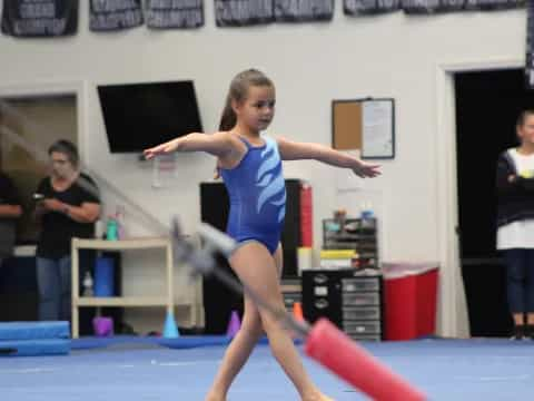 a woman in a leotard doing a gymnastics trick