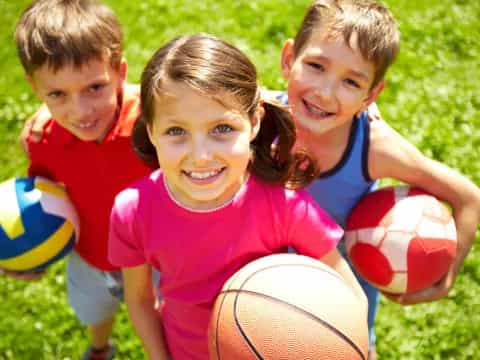 a group of kids holding balls