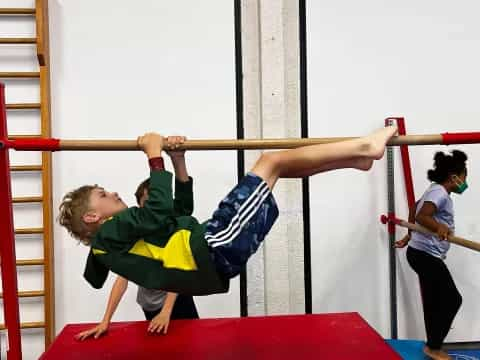 a boy doing a plank on a bar