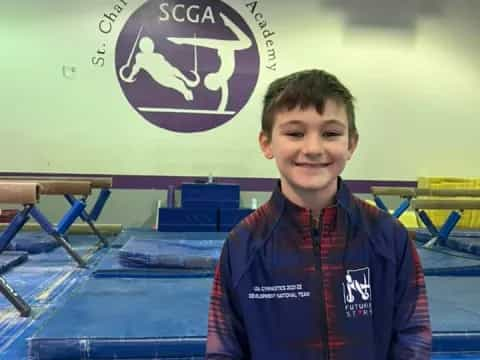 a boy standing in front of a sign