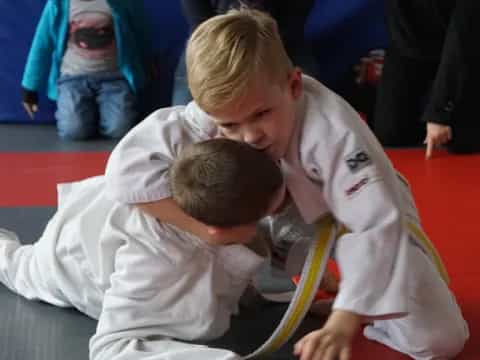 a man helping a boy do push-ups
