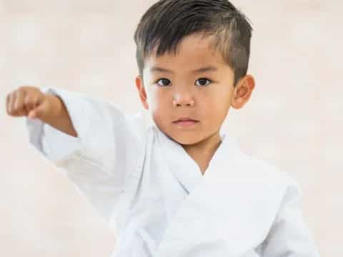 a young boy with his hand on his head