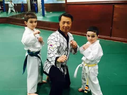 a person and two boys in karate uniforms