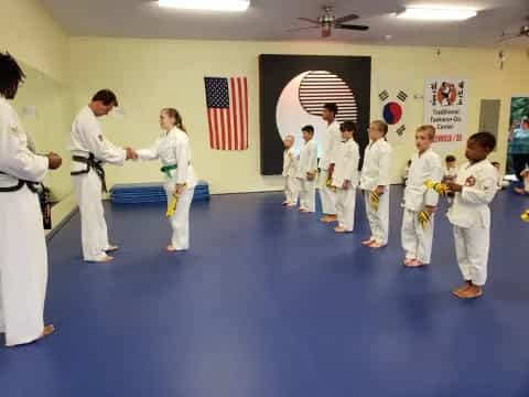 a group of people in white karate uniforms