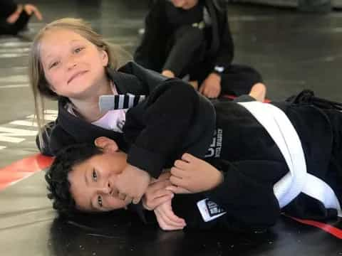 a couple of children lying on the ground posing for the camera