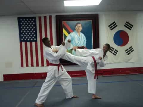 a man and a woman in karate uniforms in front of a flag