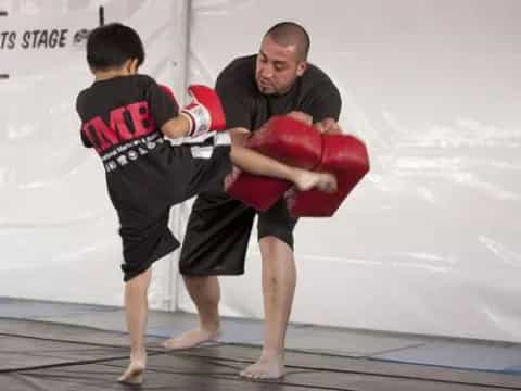 a man holding a boy in a boxing ring