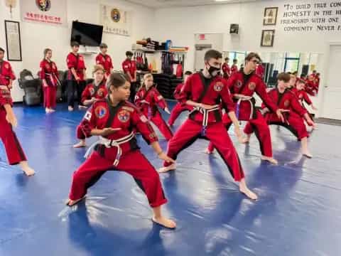 a group of people in red karate uniforms in a room