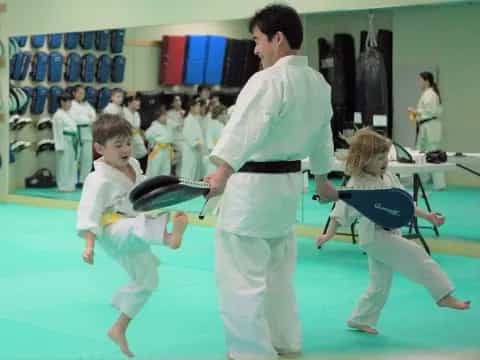 a man and a couple children in karate uniforms