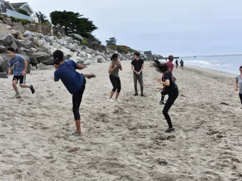 a group of people running on a beach