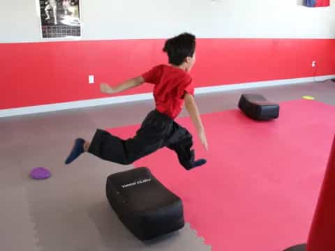 a boy jumping on a trampoline