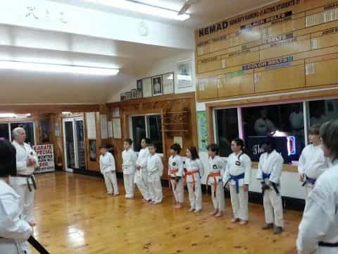 a group of people in white karate uniforms in a room