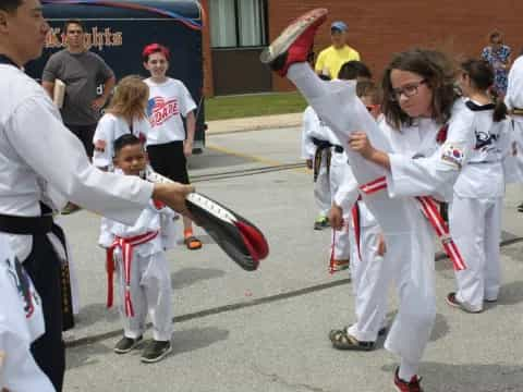 a group of people in white karate uniforms holding swords