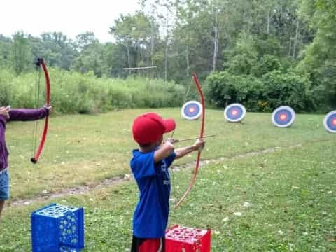 a group of kids playing with bows and arrows