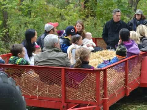 a group of people sitting in a red tractor