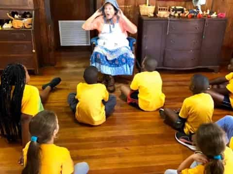 a person in a blue dress surrounded by children