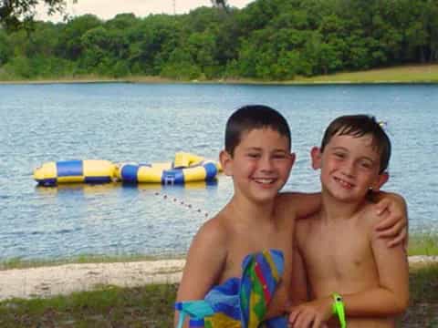 two boys sitting on a dock