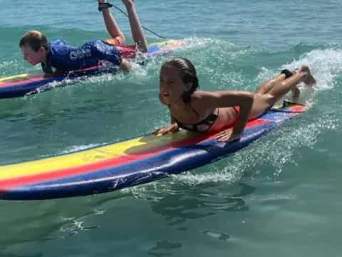 a couple of people on a surfboard in the water