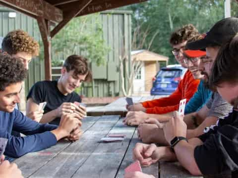 a group of people sitting around a table outside