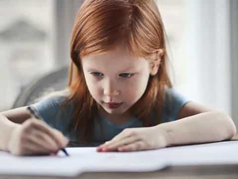 a young girl looking at a book