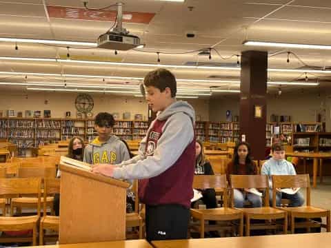 a boy standing in a classroom