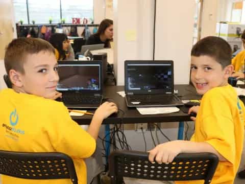 a few young boys using laptops
