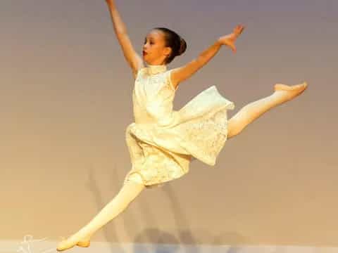 a woman in a white dress dancing