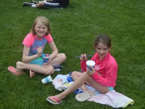 two girls sitting on the grass