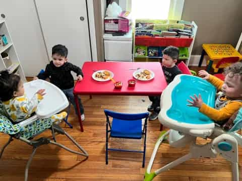 a group of kids eating at a table