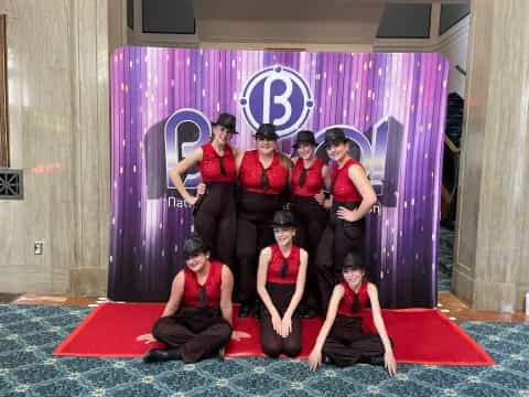 a group of women in red dresses