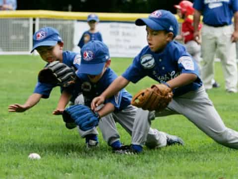 a group of kids playing baseball