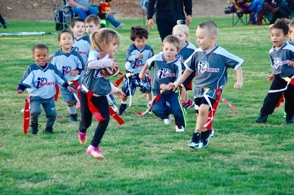 a group of kids running on a field