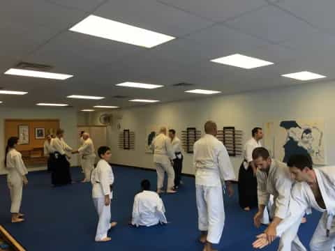 a group of people in white karate uniforms in a room