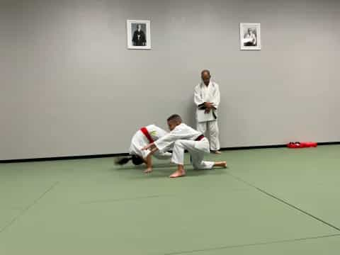 a man in a karate uniform kicking another man in the face