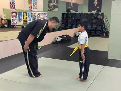 a person and a boy playing with a toy sword in a room