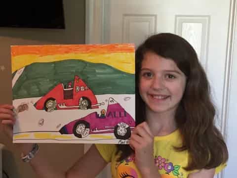 a girl holding a drawing