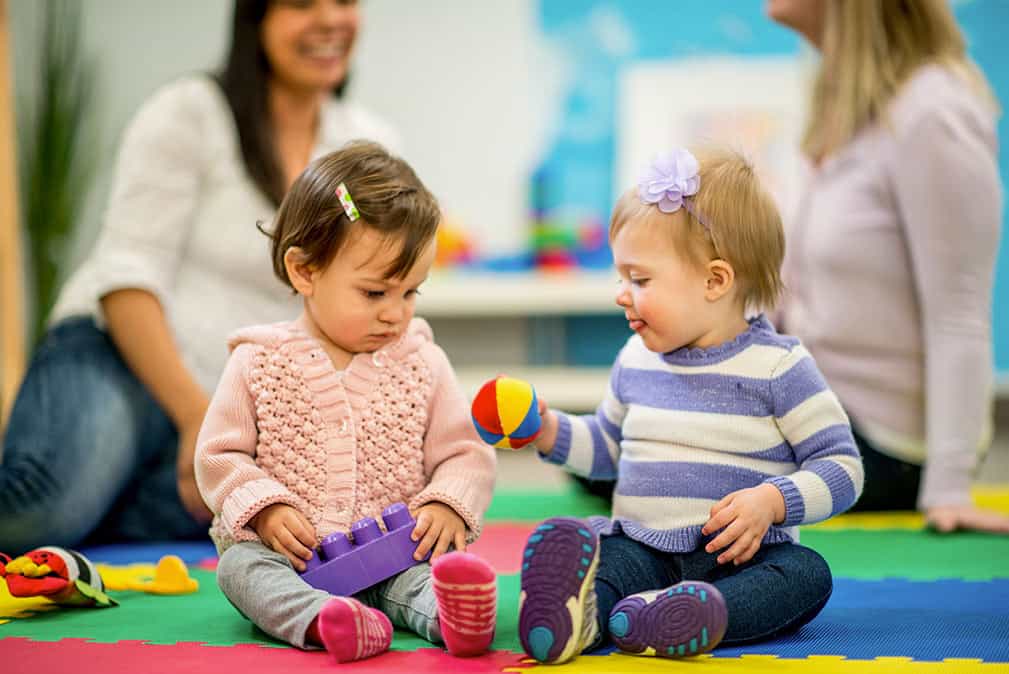 a couple of children sitting on the floor