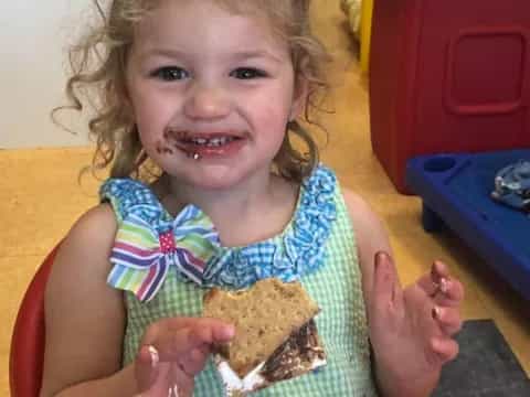 a girl holding a cookie
