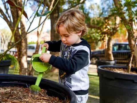 a young girl watering a tree
