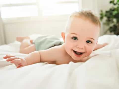 a baby lying on a bed