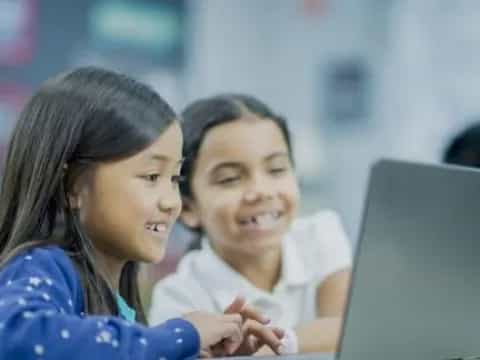 a few young women looking at a laptop