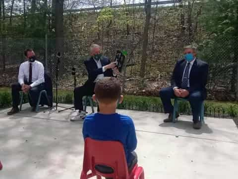 a group of people sitting on chairs outside with instruments