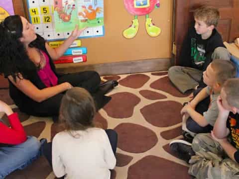 a person and several children sitting on the floor