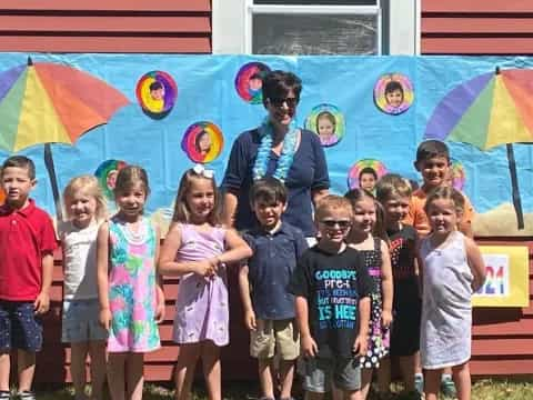 a group of children posing for a photo in front of a mural